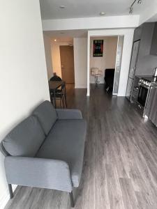 un soggiorno con un divano grigio e un tavolo di cozy room in a shared 2bedrooms condo a Toronto