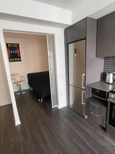 un soggiorno con frigorifero e una cucina di cozy room in a shared 2bedrooms condo a Toronto