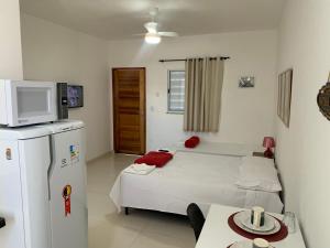 a small room with a bed and a refrigerator at Loft ROMA para Casais, em Iguaba Grande, 3 Pessoas, 150 metros da praia in Iguaba Grande