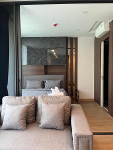 a bedroom with a bed and a couch in front of it at A303Forestkhaoyai in Ban Huai Sok Noi