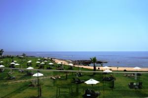 a view of a beach with umbrellas and the ocean at Amphora Hotel & Suites in Paphos