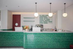 un bar verde in un ristorante con luci a ciondolo di Kotta GO Hotel Tegal a Tegal
