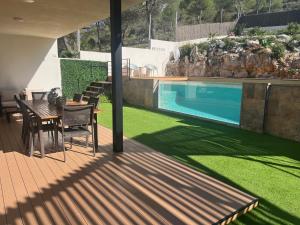 Un patio con mesa y sillas y una piscina. en Villa Vicente, en Canyelles