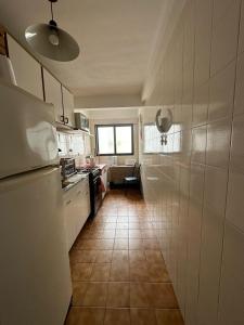 a kitchen with a refrigerator and a tile floor at Naomi in Mar del Plata