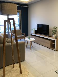 Una sala de estar con un sofá y un televisor. en Departamento MARTINIANO con cochera, en Bahía Blanca 22 fotos más