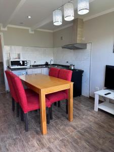 a wooden table with red chairs in a kitchen at Femiba in El Calafate