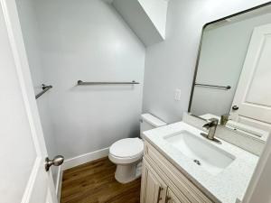 a white bathroom with a toilet and a sink at Beautiful Cozy Home in DC with Easy Parking in Washington +9 photos