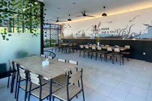 a dining room with tables and chairs and a mural at Urbanview Trunojoyo Homestay Banyuwangi by RedDoorz in Banyuwangi