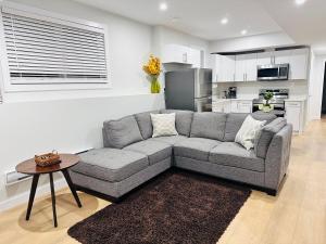 a living room with a gray couch and a table at Cozy Haven in Saskatoon