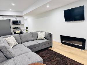 a living room with a gray couch and a flat screen tv at Cozy Haven in Saskatoon