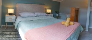 una camera da letto con un grande letto e un piumone rosa di Cabaña 2, Barrio Santa Elena a Valdivia