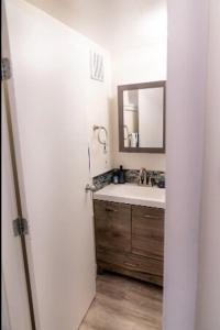 a bathroom with a sink and a mirror at Catch of the Day- Waterfront Bachelor Condo in Tofino