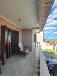 a balcony with a chair and a view of the ocean at Sobrado a Beira Mar in Rio Grande