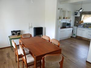 a kitchen and dining room with a wooden table and chairs at Casa de campo in Mar del Plata