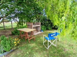 a picnic table and two chairs in a yard at Casa de campo in Mar del Plata +5 photos