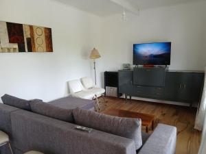 a living room with a couch and a flat screen tv at Casa de campo in Mar del Plata
