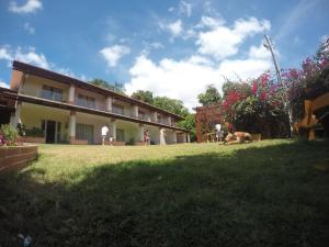 乌巴雅拉Pousada Gruta的一群人住在一座建筑旁边的院子里