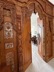 an entrance to a room with wooden doors at Villa Lisha Orolas in Blimbing