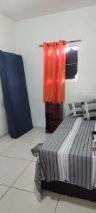 a bedroom with a bed and towels hanging on a wall at Kitnet para Hospedagem in Caruaru