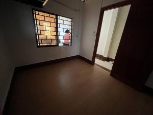 una habitación vacía con una ventana y una persona parada fuera en One Flat Apartment, en Phnom Penh