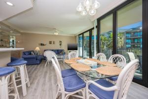 a dining room and living room with a table and chairs at Phoenix on the Bay 1314 condo in Orange Beach