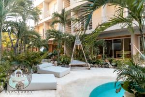 a resort with a hammock and a building at New 1BR with Jacuzzi & Free Access to Akna Beach Club in Tulum