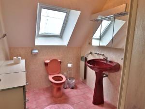 ein Badezimmer mit einer roten Toilette und einem Waschbecken in der Unterkunft Maison confortable 3 chambres, jardin, proche plages & bourg, WiFi, parking - FR-1-813-15 in Groix + 4 Fotos