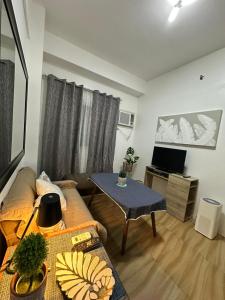 宿务Villa 2, Apple One Banawa Heights的客厅里有一张沙发和一张桌子。