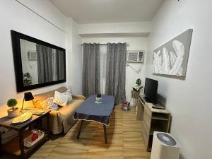 宿务Villa 2, Apple One Banawa Heights的客厅里有一张沙发和一台电视 更多3张照片