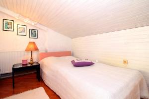 een slaapkamer met een bed en een tafel met een lamp bij Apartment Ruža 2021 in Premantura