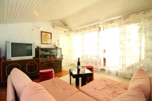 a living room with a couch and a tv at Apartment Ruža 2021 in Premantura
