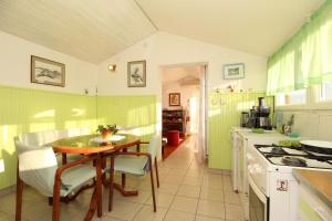a kitchen with green walls and a table with chairs at Apartment Ruža 2021 in Premantura