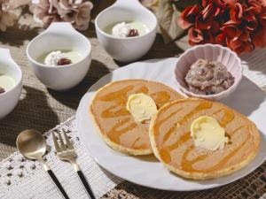 a plate of pancakes with butter and dips on a table at Hotel Gracery Asakusa in Tokyo