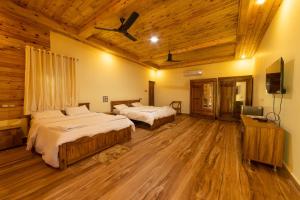 a bedroom with two beds and a flat screen tv at Oxygen Palolem in Palolem