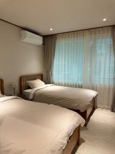 a bedroom with two beds and a window at DADU House in Seoul
