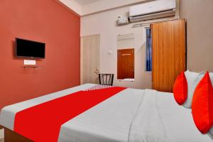 a bedroom with a large bed and a tv at Hotel O Sudipti Resort in Indore