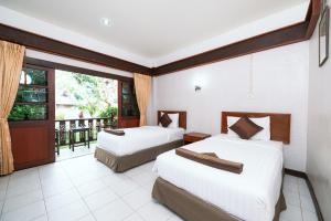 two beds in a room with a balcony at Asia Divers Resort in Ko Tao