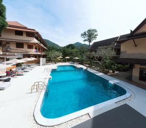 a pool at a resort with chairs and a building at Asia Divers Resort in Ko Tao
