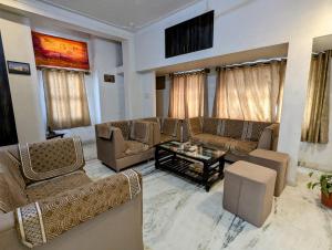 a living room with couches and a coffee table at Punia's Staycation in Udaipur
