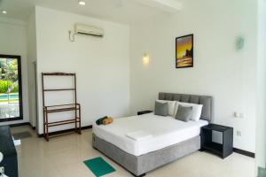 a bedroom with a large white bed and a window at Green Hill Mirissa in Mirissa
