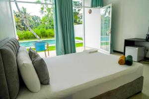 a bedroom with a large bed with a view of a pool at Green Hill Mirissa in Mirissa