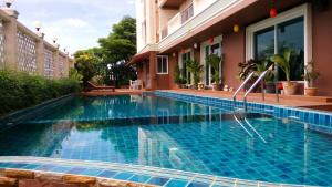 莱卡邦Convenient Grand Plus Hotel Suvarnabhumi的建筑物前的游泳池