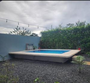 a swimming pool sitting next to a blue wall at Casa villa azul in Puerto Limón