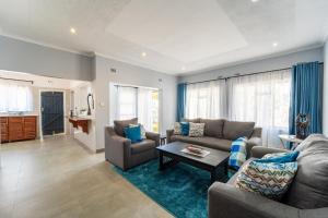 a living room with two couches and a table at KhayaLethu Vic Falls 2 in Victoria Falls
