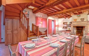ein Esszimmer mit einem langen Tisch und einem Kamin in der Unterkunft Beautiful Home In Gonneville-Le-Theil in Gonneville