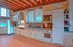 eine große Küche mit weißen Schränken und Fenstern in der Unterkunft Beautiful Home In Gonneville-Le-Theil in Gonneville