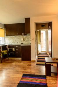 a kitchen with brown cabinets and a dining room at Apartment Leonardo Da Vinci in Plovdiv