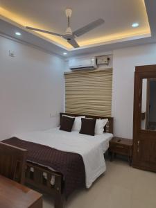 Un dormitorio con una cama con ventilador de techo. en Posh 1 BHK Apt with Temple View in Guruvayur B1001, en Guruvāyūr