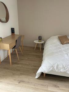 a bedroom with a bed and a desk and a table at Appart 2 Chambres au coeur de Libourne in Libourne