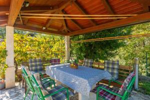 una mesa y sillas bajo un techo de madera en Traumhafte Finca mit Tischtennis, Spielplatz, Basketballplatz, Privatpool, Outdoor-Kueche, en Pazin